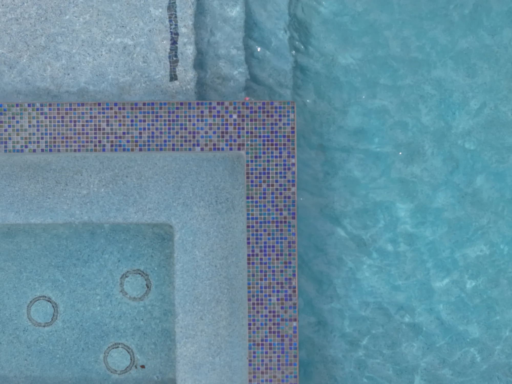 Blue pool water and light aggregate finish in a desert backyard