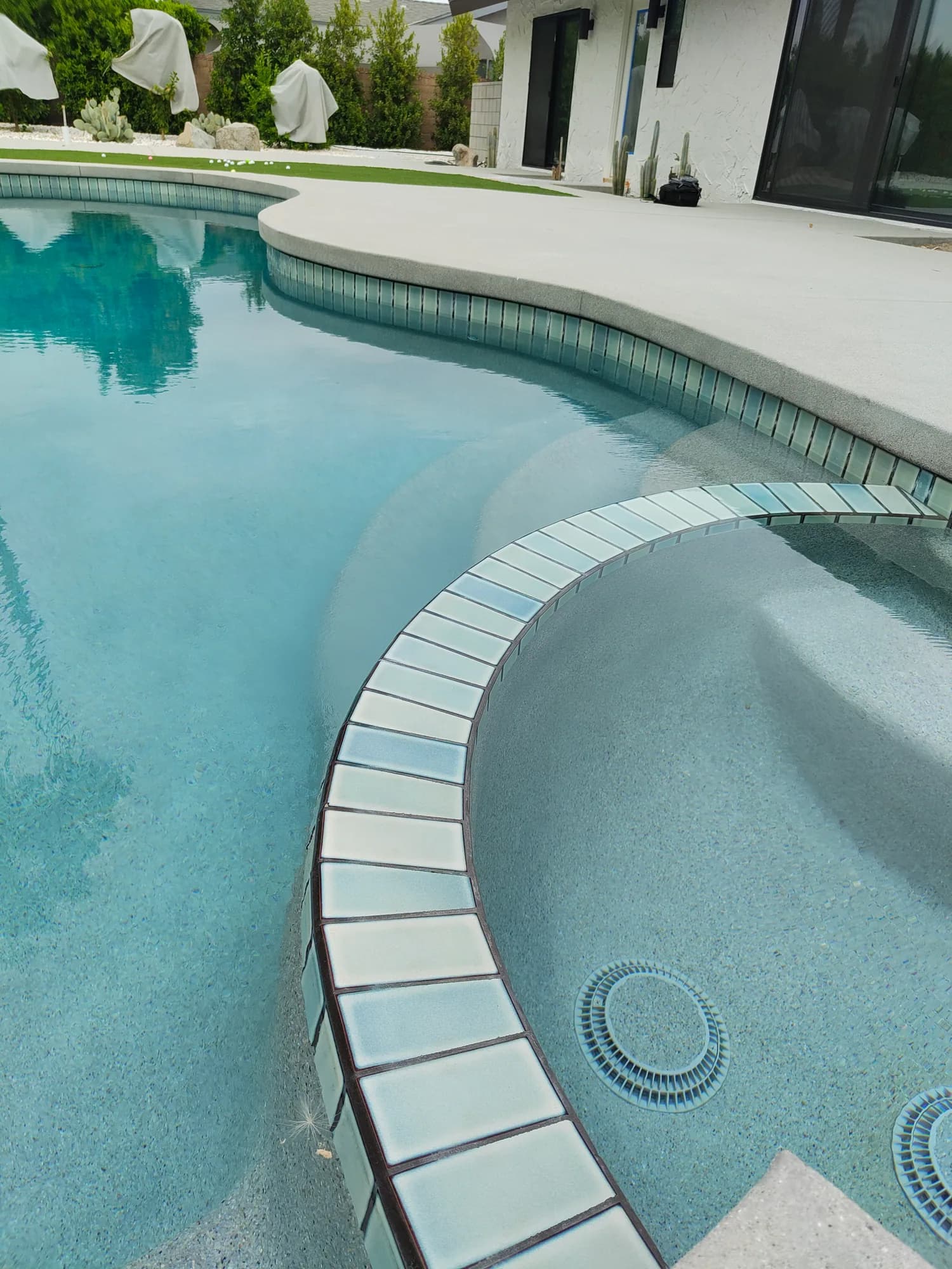 Curved pool edge, waterline tile, and circular spa at the Pebble Beach project