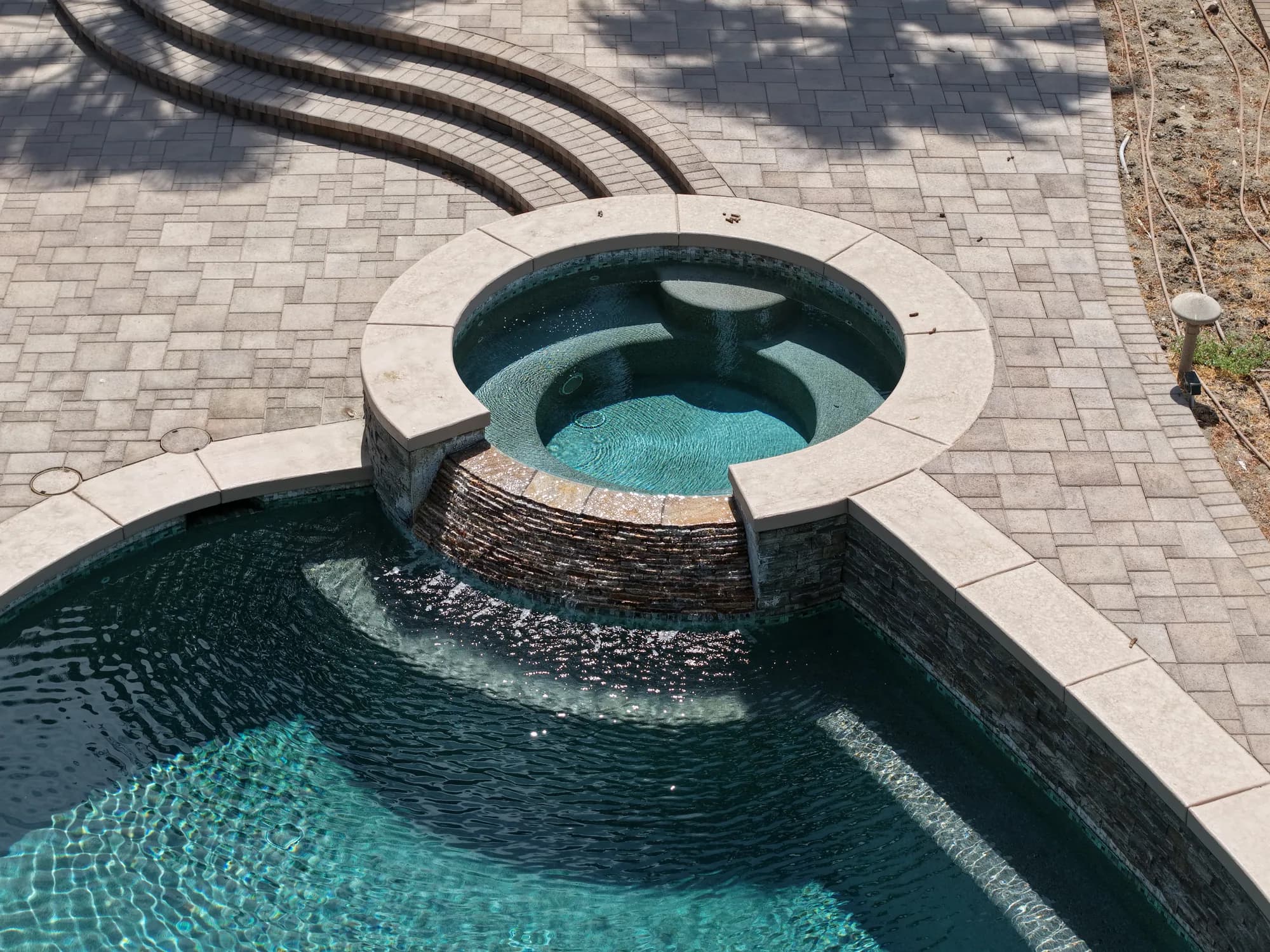 Round raised spa with a spillway into the PWG 2 pool